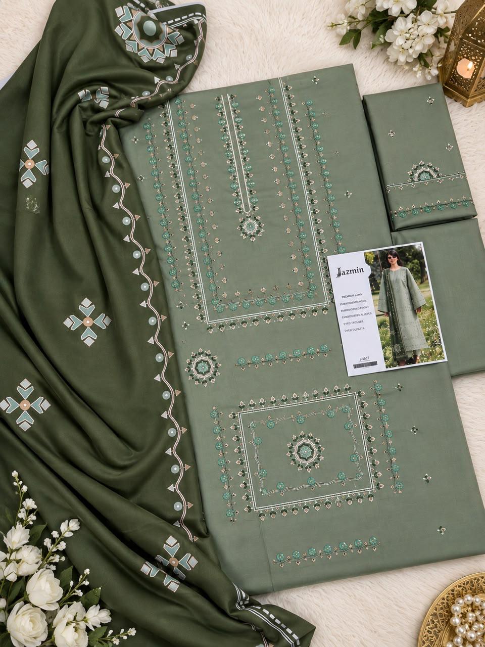 An olive green ethnic salwar kameez suit set with intricate silver and turquoise embroidery, featuring a dupatta, kurta, and matching trousers, styled with white flowers on a white textured background.
